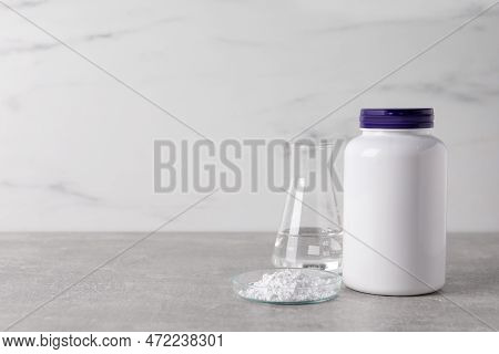 Petri Dish With Calcium Carbonate Powder, Jar And Laboratory Flask On Light Grey Table. Space For Te