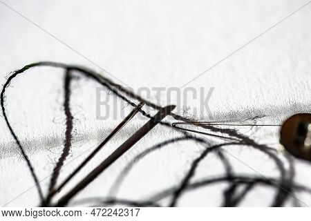 Sewing Needle Threader Tool In Use And A Single Black String.