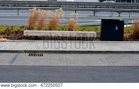 Perennial Bed Mulched With Gray Gravel In Front Of A Limestone Stone Wall In A Square With Benches W