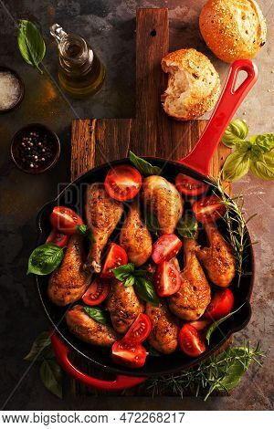 Roasted Chicken Drumsticks In A Cast Iron Pan With Tomatoes And Basil