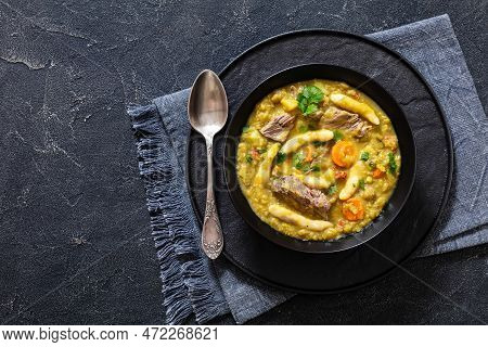 Gungo Peas, Pigeon Peas Soup With Dumplings And Beef In Black Bowl On Concrete Table With Spoon, Jam