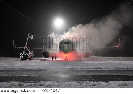 Ground Deicing Of A Passenger Airplane On The Night Airport Apron At Winter