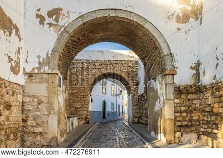 Resting Arch In Medieval Walls Is One Of 4 Entrances To The Old Town In Faro, Algarve, Portugal