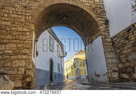 Resting Arch In Medieval Walls Is One Of 4 Entrances To The Old Town In Faro, Algarve, Portugal