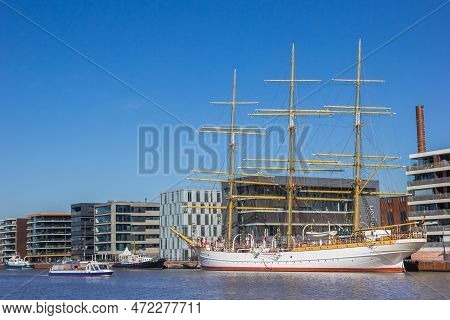 Bremerhaven, Germany - March 09, 2022: Tall Ship In Front Of Apartment Buildings In De New Harbor Of