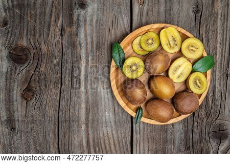 Closeup Ripe Golden Kiwi Fruit On Wooden Background. Healthy Fruits Concept. Place For Text, Top Vie