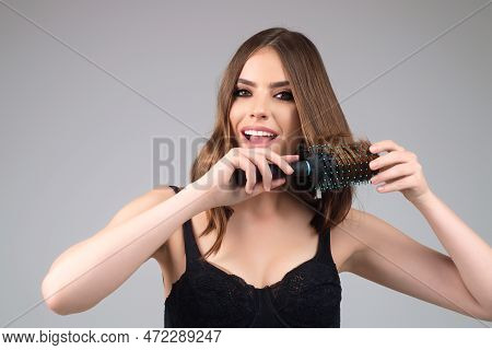 Beautiful Model Girl With Comb Brushing Hair. Beauty Woman With Straight Hair On Studio Background. 