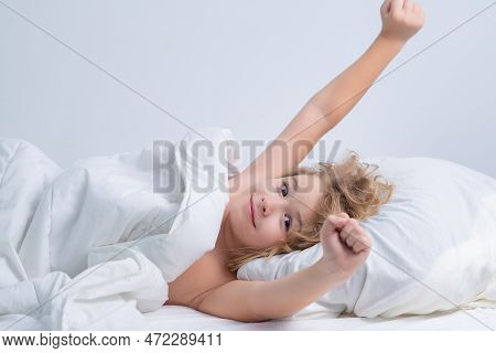 Kid Waking Up And Stretching, Raised Hands. Morning Awakening Little Child In Bed. Kid Wakes Up In T