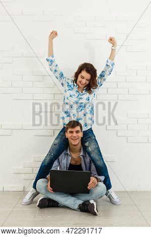 Portrait Of Happy Young Couple Using Laptop On Gray Background