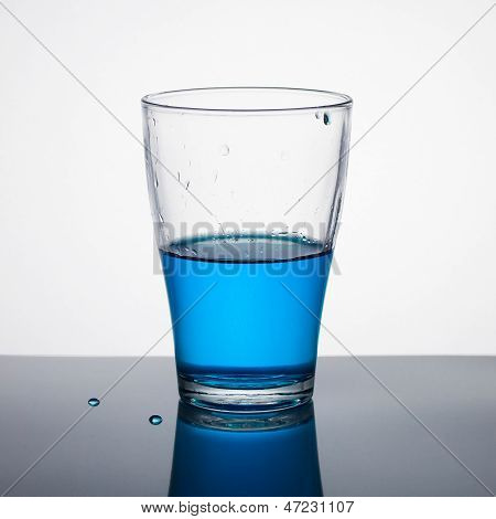 Glass Half Full Of Blue Liquid