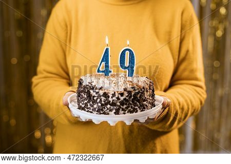 Woman Holding A Delicious Cake With Number 49 Candles While Celebrating Birthday Party. Birthday Hol