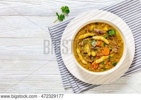 Gungo Peas, Pigeon Peas Soup With Dumplings , Vegetables And Beef In White Bowl On White Wood Table,