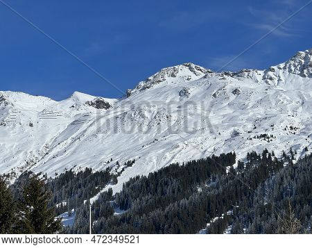 Beautiful Sunlit And Snow-capped Alpine Peaks Above The Swiss Tourist Sports-recreational Winter Res