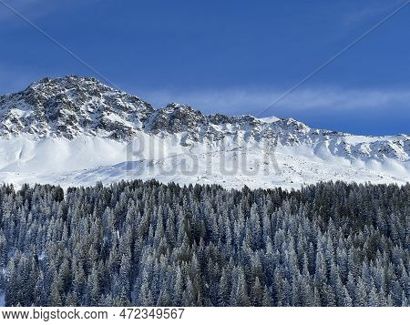 Beautiful Sunlit And Snow-capped Alpine Peaks Above The Swiss Tourist Sports-recreational Winter Res