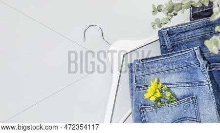 Romantic Spring Shopping Banner With Different Kind Of Jeans With Flower And White Hanger On Blue Ba