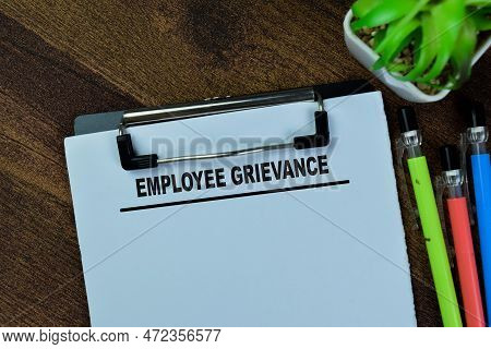 Concept Of Employee Grievance Write On Paperwork Isolated On Wooden Table.
