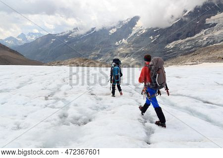 Group Of People Hiking On Glacier And Mountain Snow Panorama In Glockner Group, Austria