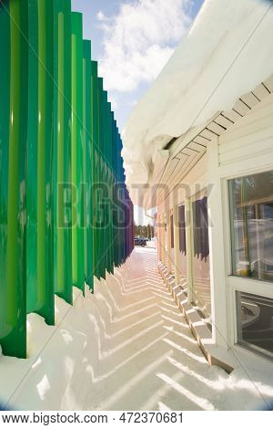 Beautiful Building With Green Columns. Pattern With Shadows On The Snow
