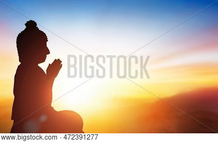 Buudha Head And Side Body Statue With Sunset Background As Golden Aura.