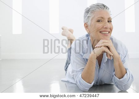 Ritratto di lunghezza completa di donna senior sdraiato sul pavimento