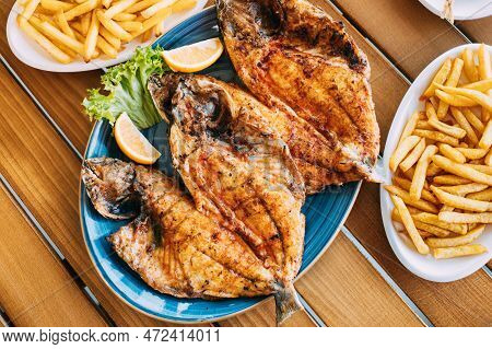 Dish With Gilt-head Bream Fish With Orange And French Fries. Dorada, Dorade, Dorado, Dourada Fish An
