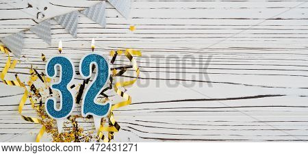 Number 32 Blue Celebration Candle On White Wooden Background. Happy Birthday Candles. Concept Of Cel