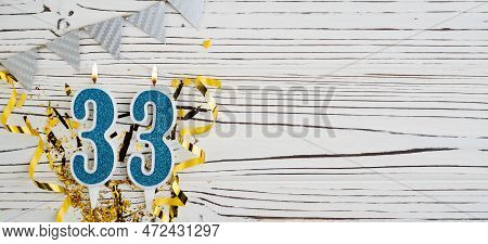 Number 33 Blue Celebration Candle On White Wooden Background. Happy Birthday Candles. Concept Of Cel