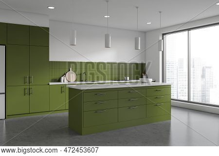 Corner Of Stylish Kitchen With White Walls, Concrete Floor, Green Cupboards And Cabinets And Green I