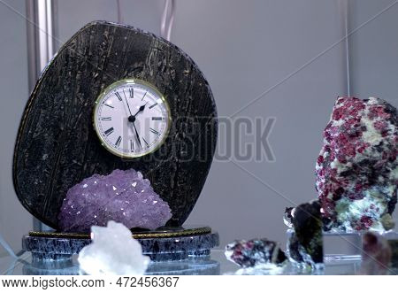 A Table Clock Made Of Stone, Displayed In A Showcase Among Minerals