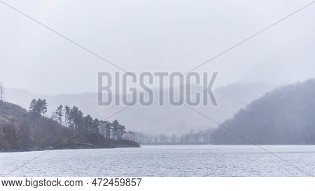 Beautiful Calm Peaceful Winter Landscape Over Thirlmere In Lake District With Fog And Layers Of Tree