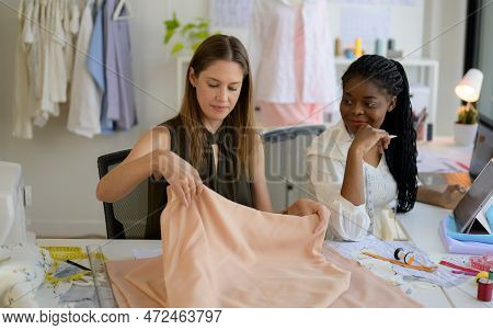 Happy Female Dressmaker Working In Workshop Studio