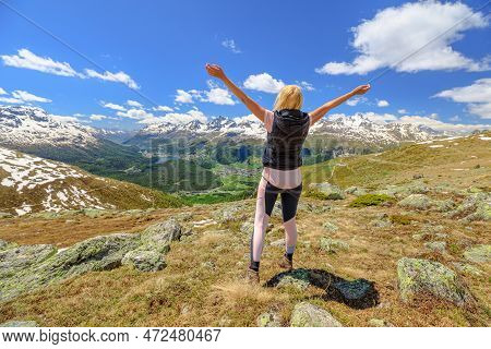 Tourist Woman At Sunset Trekking On Top Of Muottas Muragl In Switzerland. Popular Mountain Excursion