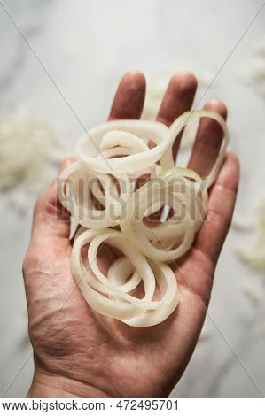 Ring Sliced Onions On Mans Hand. Photo Show How Does Onion Sliced Into Thin And Thick Rings Look Lik