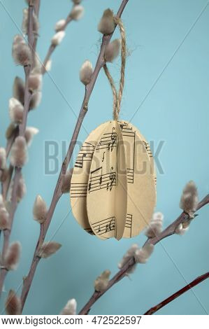 On A Blue Background Paper Eggs Hang On Willow Branches For Easter. Diy Crafts Bulky Paper Eggs As A