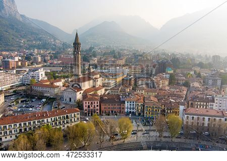 Foggy Aerial Sunrise Cityscape Of Lecco Town On Spring Day. Picturesque Waterfront Of Lecco Town Loc