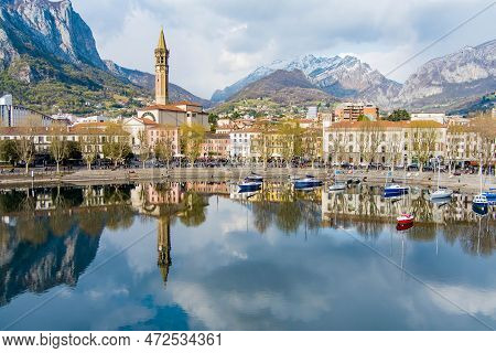 Sunny Aerial Cityscape Of Lecco Town On Spring Day. Picturesque Waterfront Of Lecco Town Located Bet