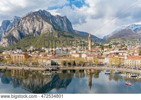 Sunny Aerial Cityscape Of Lecco Town On Spring Day. Picturesque Waterfront Of Lecco Town Located Bet