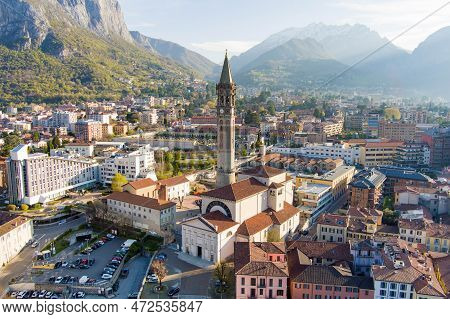 Sunny Aerial Cityscape Of Lecco Town On Spring Morning. Picturesque Waterfront Of Lecco Town Located