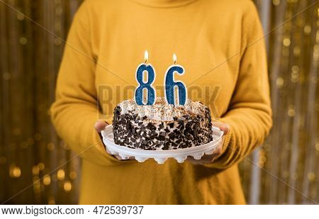 Woman Holding A Festive Cake With Number 86 Candles While Celebrating Birthday Party. Birthday Holid