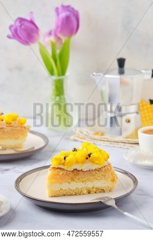 Sliced Biscuit Cake With Cream Cheese Cream, Lemon Layer And Yellow Biscuit Decor On A Ceramic Plate