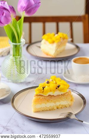 Sliced Biscuit Cake With Cream Cheese Cream, Lemon Layer And Yellow Biscuit Decor On A Ceramic Plate