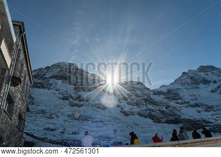 Eigergletscher, Canton Bern, Switzerland, February 11, 2023 Sun Is Rising Behind The Snow Covered Al