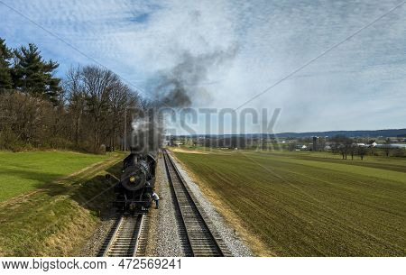 A Head On Aerial View Of A Steam Engine Waiting, All Steamed Up, While The Engineer Checks And Oils 