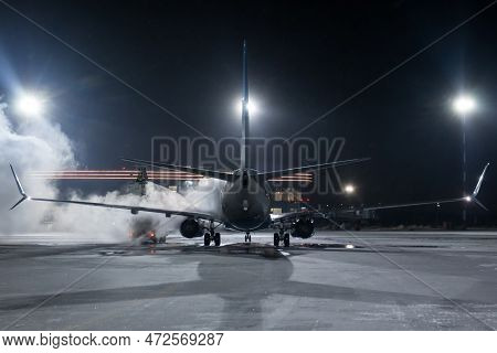 Ground Deicing Of A Passenger Airliner On The Night Airport Apron At Winter