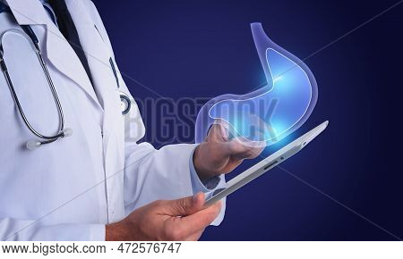 Symptoms And Treatment Of Heartburn And Other Gastrointestinal Diseases. Doctor Using Tablet On Blue
