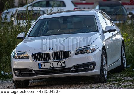 Side, Turkey - February 13, 2023:     White Bmw F01   Is Parked  On The Street On A Warm Day