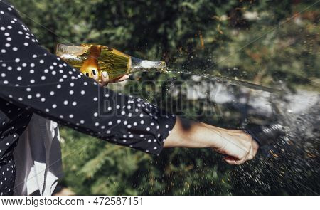 Young Woman Opens A Bottle Of Sparkling Wine By The Knife. Sabrage. Close Up.
