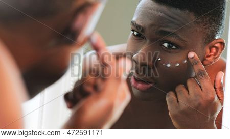 Facial Cream. Skin Treatment. Anti-aging Skincare. Closeup Of Man Applying Under Eye Face Moisturizi