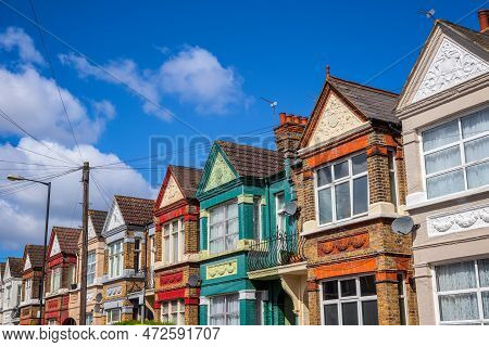 A Row Of Colourful Terraced Houses Around Kensal Rise In London With Overhead Cable Lines