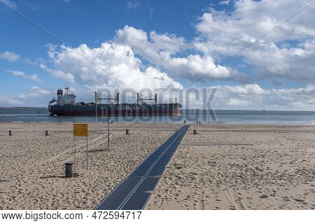 Cargo Ship Cruises In Front Of The Beach At Boulevard Evertsen In Vlissingen. Provinz Zeeland In The